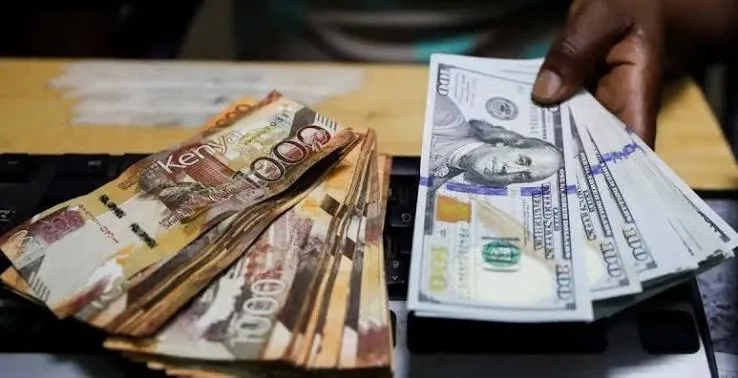 Kenyan shillings counted out beside US dollars